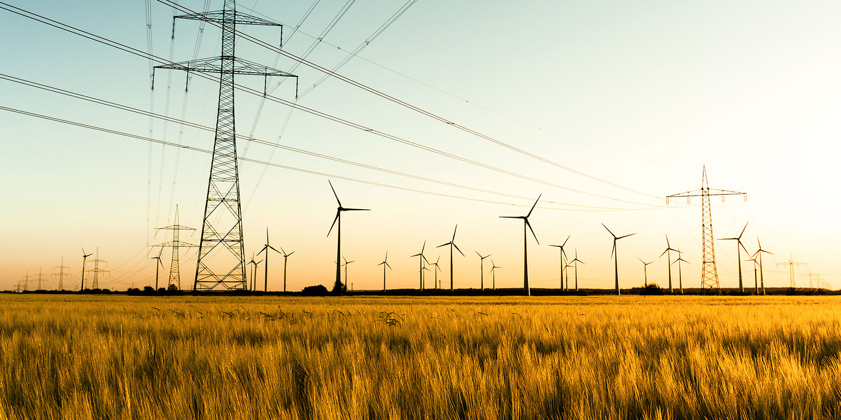 Strommasten, Feld und Windräder stehen für die Erzeugung und Weitergabe von Energie und Strom