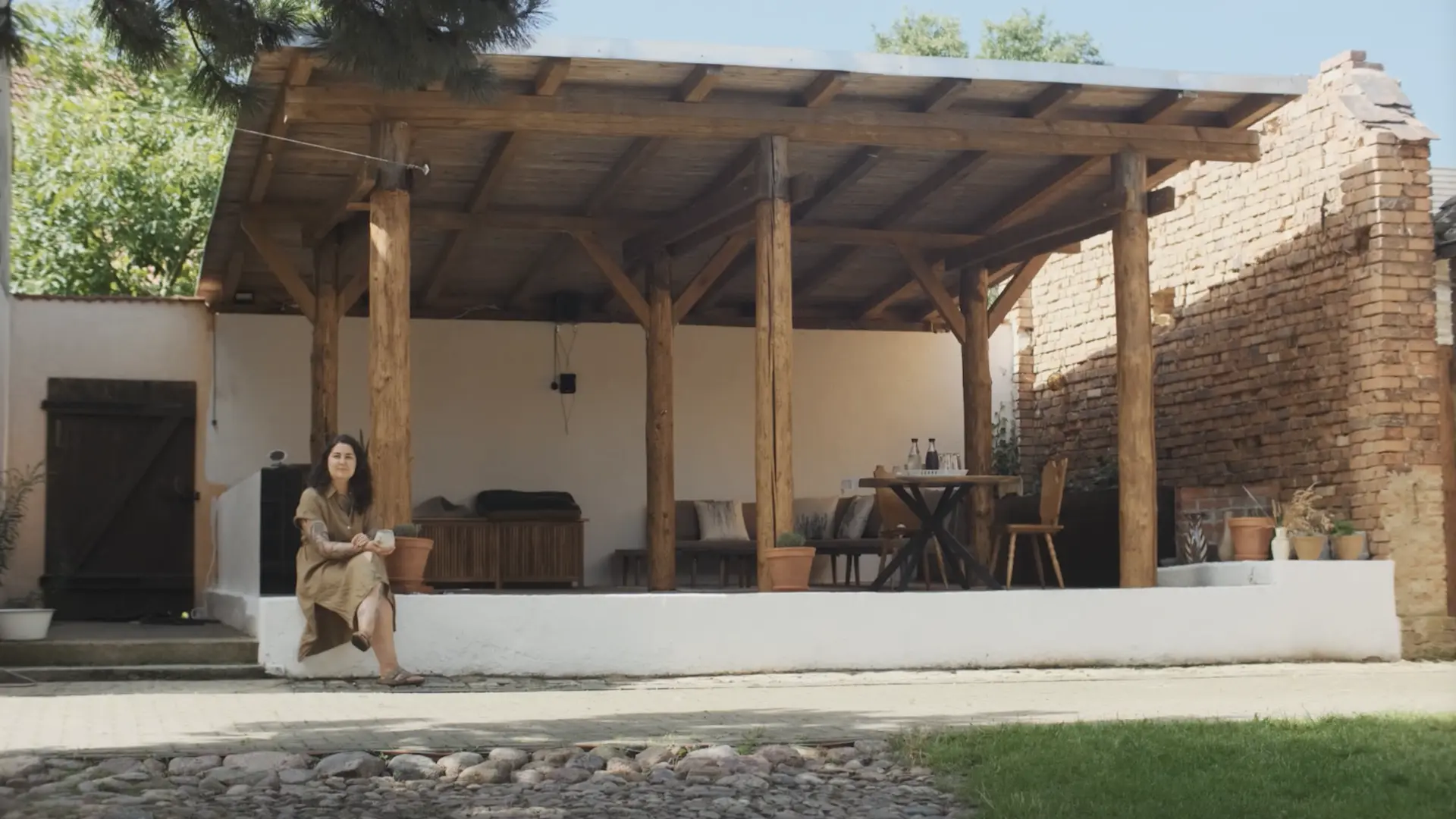 Bea sitzend auf der Terrasse ihres neuen Hauses