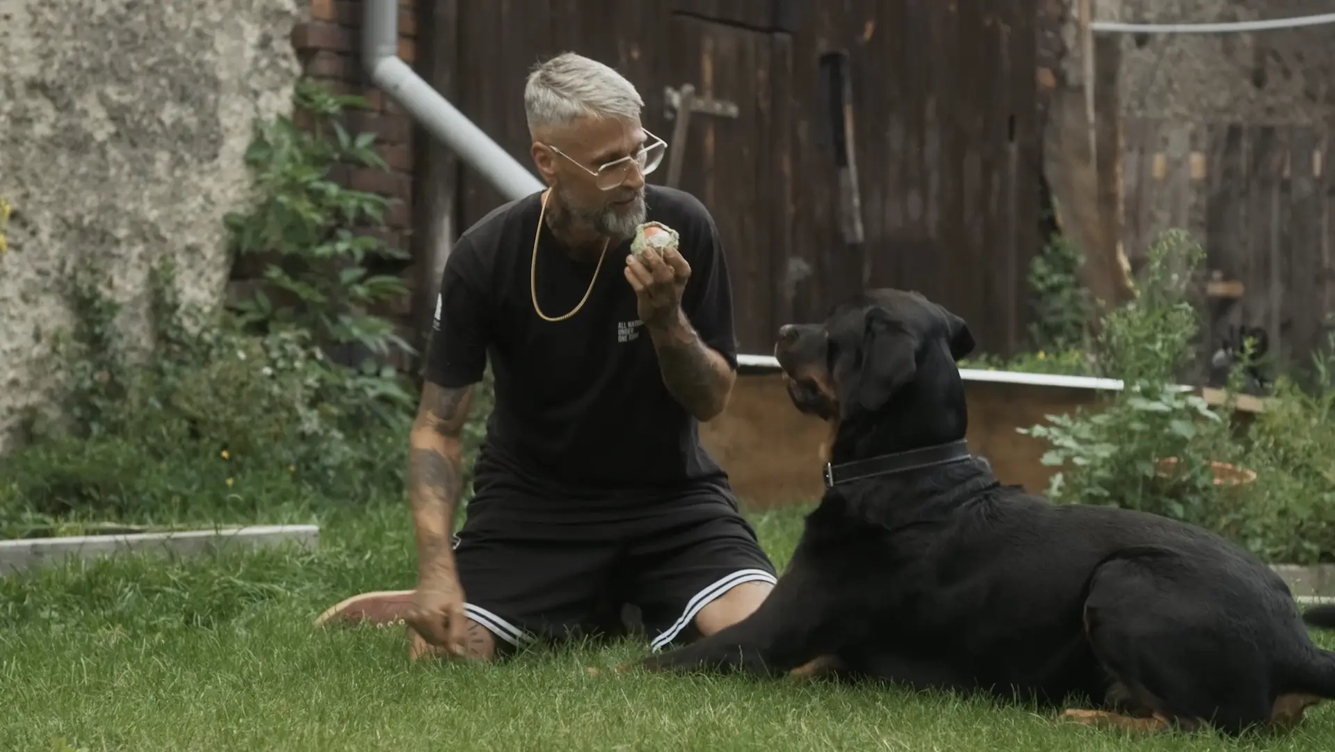 Daniel mit dessen Hund kniend im Garten