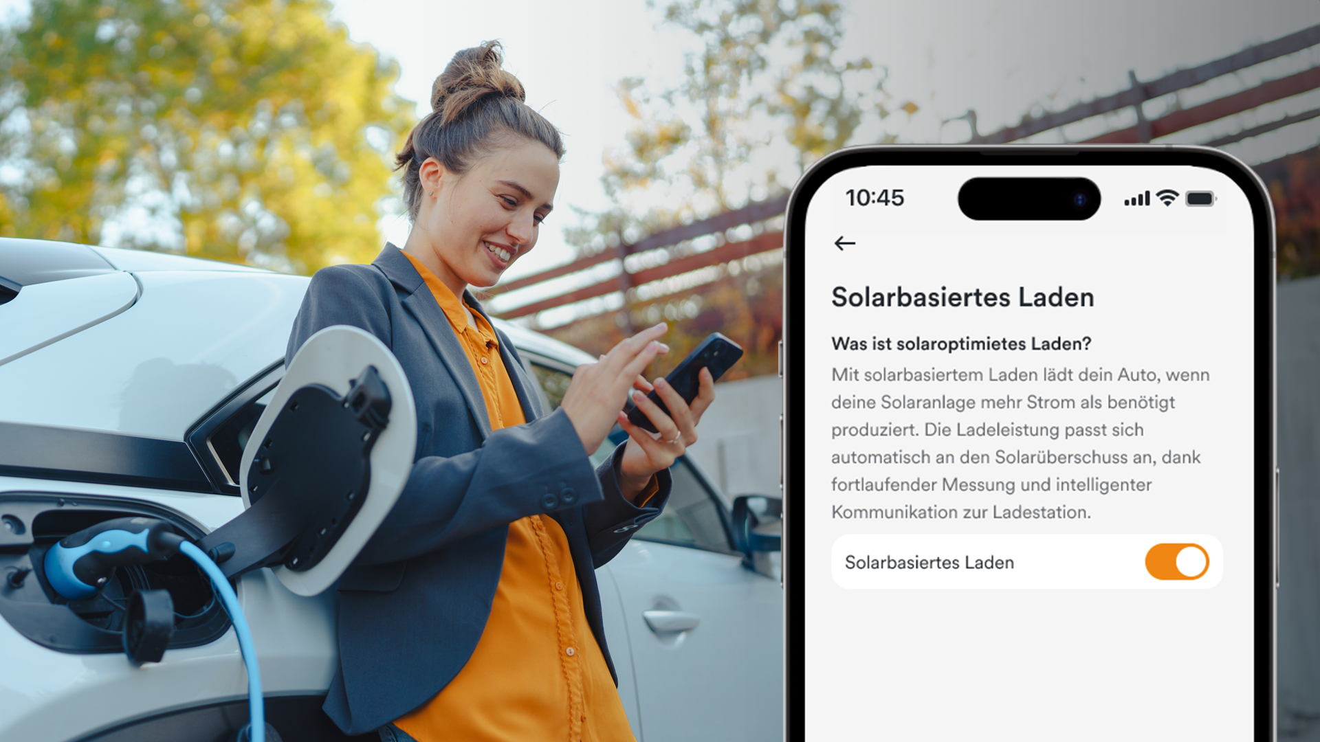 Frau vor E-Auto, was gerade lädt. Frau schaut auf ihr Handy, Handy-Display im Vordergrund eingeblendet: Solaranlage App AMPERE.IQ zeigt die Funktion "Solarbasiertes Laden des E-Autos an"