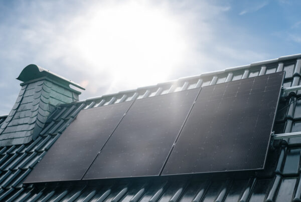 Ausschnitt eines Hausdachs mit drei Solarmodulen