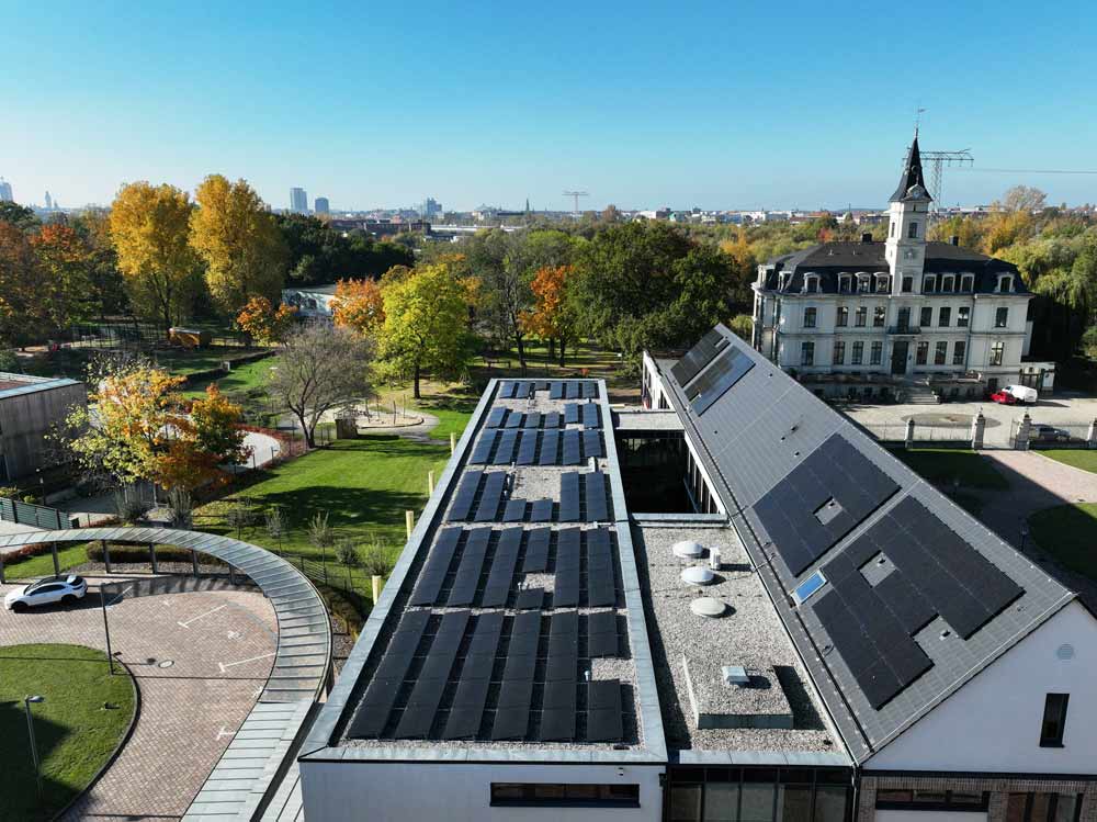 PV-Großanlage auf dem Dach der Förderschule Schloss Schönefeld, Blick über das Gelände und die Stadt Leipzig