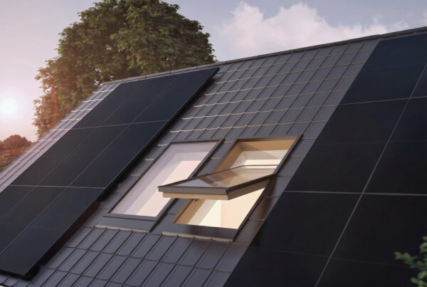 Hausdach mit Solarmodulen und Baum im Hintergrund